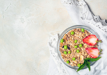 Sweet country breakfast: granola with strawberries and Green peas on vintage background. healthy eating concept. Top view, flat lay