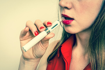 Close up of a woman holding and smoking e-cigarette