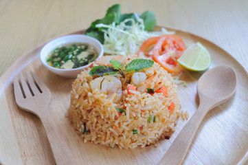 Homemade Chinese fried rice with vegetables, shrimp in spicy taste served on a wooden plate with wooden spoon - 160723033