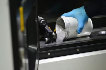 man pours metal powder into the chamber of a laser sintering machine. 3D printer printing metal....