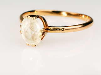 Golden ring with gem over white