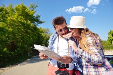 Cheerful young couple on a sunny day reading map