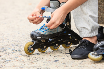 Woman putting on roller skates outdoor.