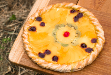 Fruit pizza with pineapple, orange, kiwi, cherry