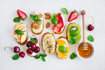 set summer sweet snacks. Bruschetta or sandwiches with fruit and berries. Top view