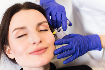 A woman on the procedure of injections in a cosmetology clinic