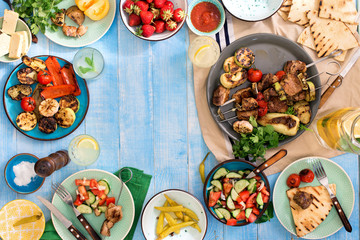 Frame of shish kebab, grilled vegetables, salad, snacks, strawberries, lemonade