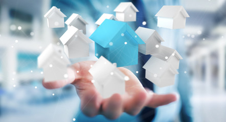 Businessman using 3D rendered small white and blue houses