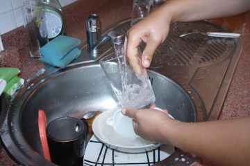a woman washes dishes in the kitchen