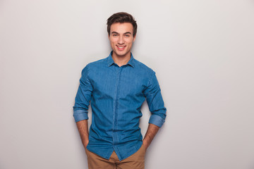 happy casual man with hands in pockets smiling
