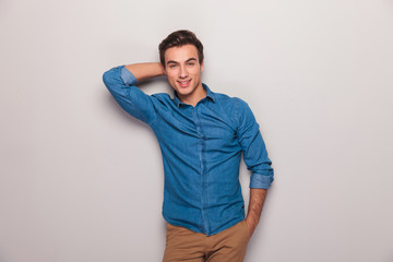 smiling man posing for the camera with hand behind head