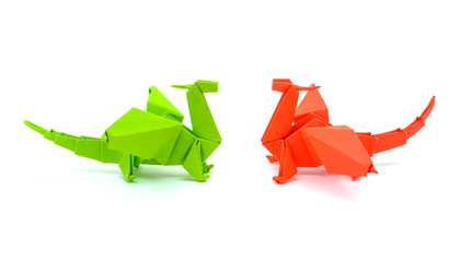 Photo of origami green and red dragons isolated on white background