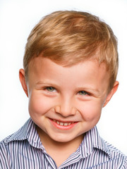 His first experience to make photo for passport or ID card. Emotionally grimacing little boy with blond hair and bright green eyes. White background.