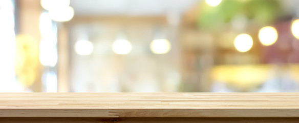 Wood table top on blur restaurant interior background