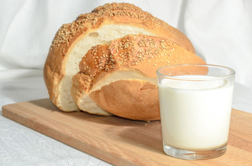 Homemade bread, sliced on a wooden board with milk