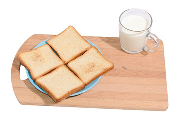 Square toast on a blue plate on a wooden board and a mug of milk
