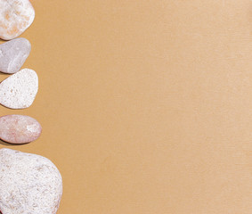 Fototapeta na wymiar Gray pebbles on brown textured paper, background