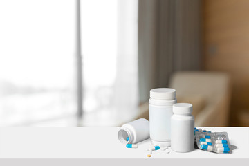 white medicine capsules pouring from bottle