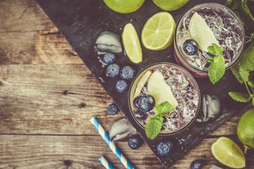 Blueberry mojito on rustic wood background