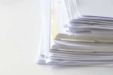 Stack of business documents on white table with high key tone. 