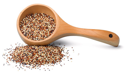 dried quinoa in the wooden spoon on the white background, (large depth of field, taken with tilt...