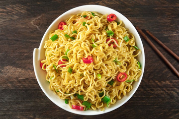 Instant noodles with vegetables, chopsticks, and copy space