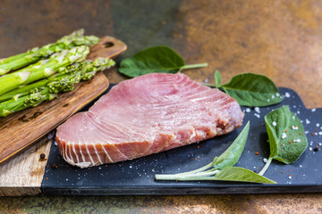 Fresh tuna steak with herbs and green asparagus.