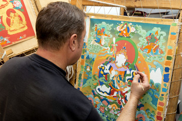The artist paints a Buddhist icon