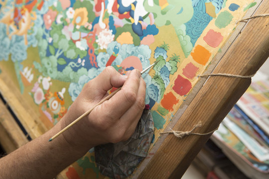 The artist paints a Buddhist icon