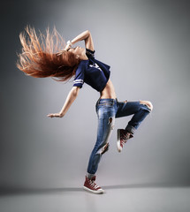 modern young beautiful dancer posing on a studio background