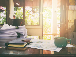 A cup of coffee and office supplies in meeting room at morning