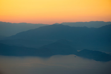 Orange sunset in the mountains. View from a height.