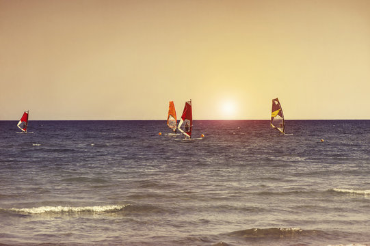 Windsurfers in the sea on Cyprus on sunset. Windsurfing in Larnaca