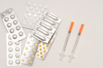 Contraceptive tablets in packages and without on a light background.