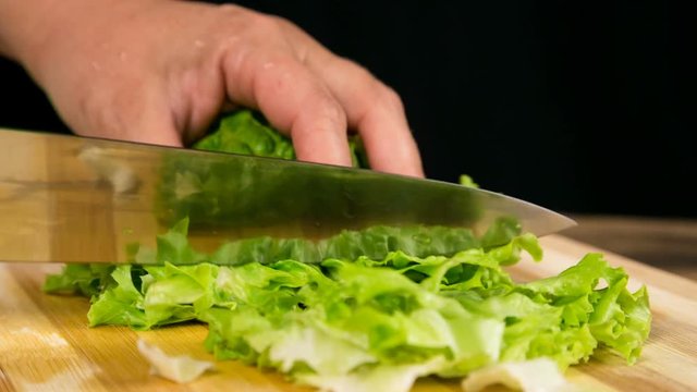 Closeup of cut green salad leaf on cutting board