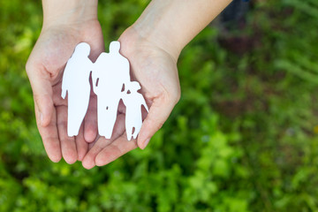 Woman hands holding wooden family shape. Love and relationships concept