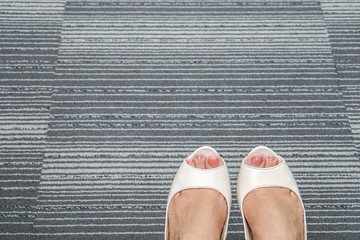 close up white women high heel shoes on office carpet