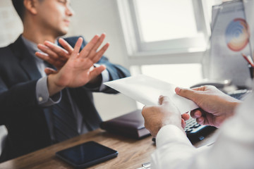 Businessman rejecting money in white envelope