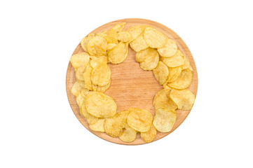 Round wooden board with potato chips isolated on white. Top view.