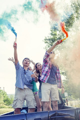 Group of young guys have fun with colored smoke trails