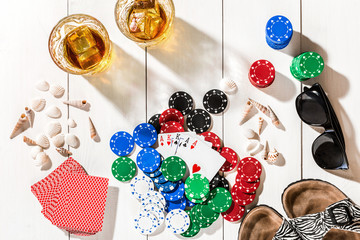 Poker. Set to playing poker with cards and chips on white wooden table, top view