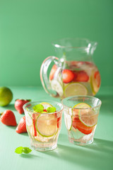 refreshing summer drink with strawberry cucumber lime in jar and glasses