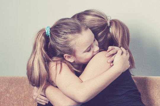 Daughter hugging his mother at home. Concept of couple family is in sorrow