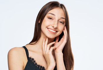 Fototapeta premium Woman with smile, woman holding hands near face, woman on light background