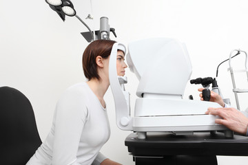 woman doing eyesight measurement with optician slit lamp