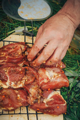 Raw pork steak on ribs. On the grill pan. Male hand puts the meat on the grill