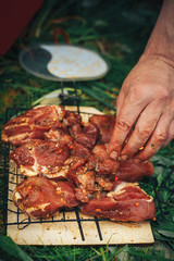 Raw pork steak on ribs. On the grill pan. Male hand puts the meat on the grill