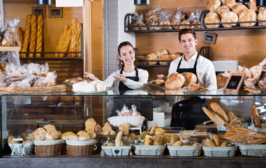 Portrait of charming  couple at bakery display with pastry
