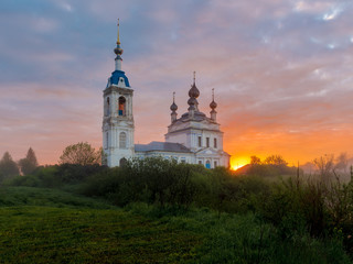 Fototapeta na wymiar Foggy sunrise in the village Savinskoye, Yaroslavl region. Russia. The Church Of The Nativity Of The Blessed Virgin. 
