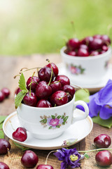 Cherries in the cup on wooden table